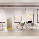 A pair of grey Senator Ousby mesh chairs at a shared workstation in a bright and modern open-plan office