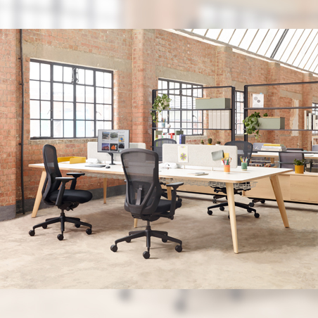 Two black Senator Ousby mesh chairs shown at a large workstation in a modern